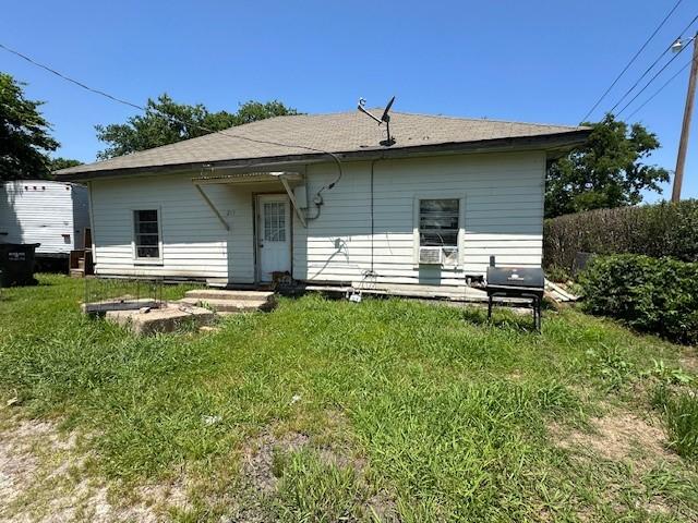rear view of property featuring a yard