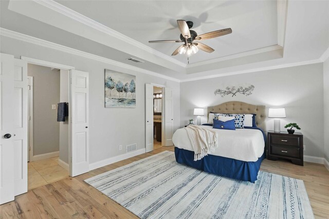 4636 Versailles Ln, Plano, TX 75093 - bedroom featuring a tray ceiling, wood finished floors, baseboards, crown molding, and connected bathroom