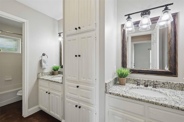 4636 Versailles Ln, Plano, TX 75093 - bathroom with two vanities, wood finished floors, and baseboards