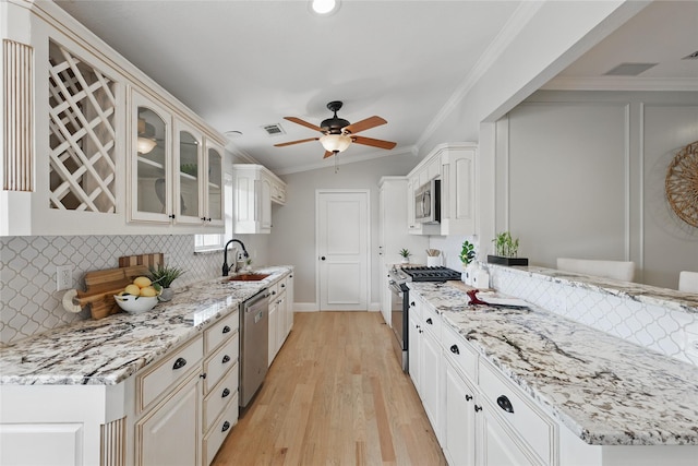 4636 Versailles Ln, Plano, TX 75093 - kitchen featuring stainless steel appliances, a sink, backsplash, light stone counters, and crown molding