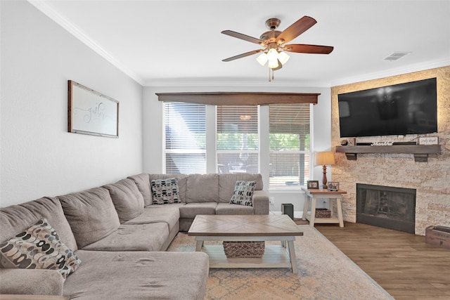 6105 Sidney Ln, Mckinney, TX 75070 - living area with ornamental molding, wood finished floors, a ceiling fan, plenty of natural light, and a stone fireplace