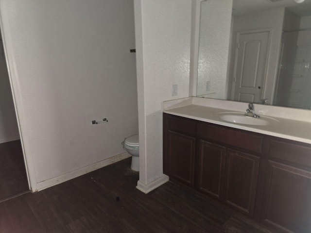 1322 Lucchese Ln, Dallas, TX 75253 - bathroom with wood finished floors, toilet, vanity, and baseboards