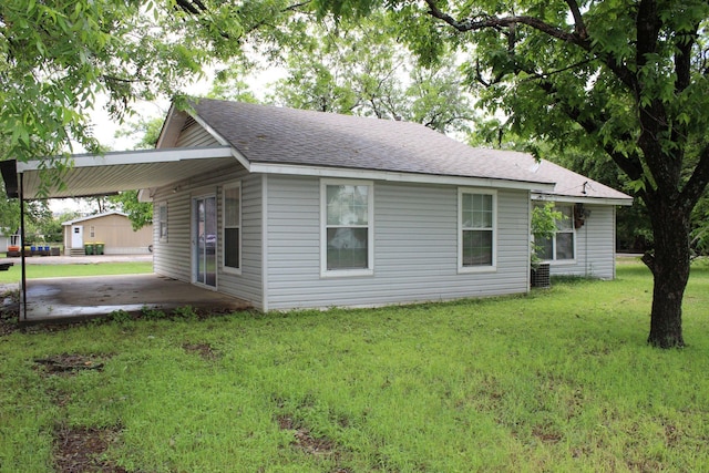 4207 Harrison St, Bellmead, TX 76705 - view of side of home featuring a lawn, roof with shingles, and a carport
