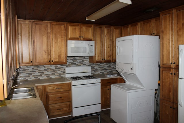 4207 Harrison St, Bellmead, TX 76705 - kitchen with white appliances, stacked washer and clothes dryer, a sink, brown cabinets, and wood ceiling