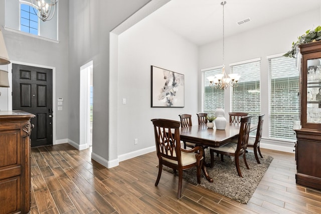 1319 Bridgewater Blvd, Celina, TX 75009 - dining room featuring a chandelier, baseboards, dark wood-style flooring, and a towering ceiling
