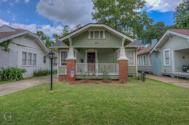 craftsman-style house featuring covered porch and a front lawn