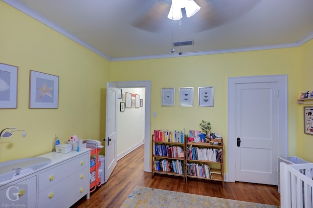 bedroom with crown molding, wood finished floors, and a ceiling fan