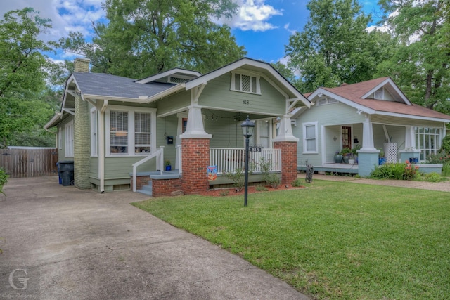 craftsman house with a porch, a chimney, concrete driveway, and a shingled roof
