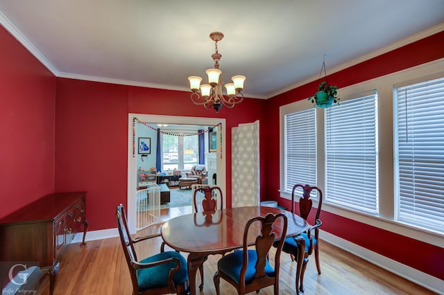 dining space with a chandelier, baseboards, wood finished floors, and ornamental molding