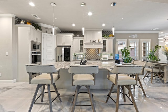 2604 Coyote Xing, Rockwall, TX 75087 - kitchen with appliances with stainless steel finishes, tasteful backsplash, ornamental molding, glass insert cabinets, and light stone countertops