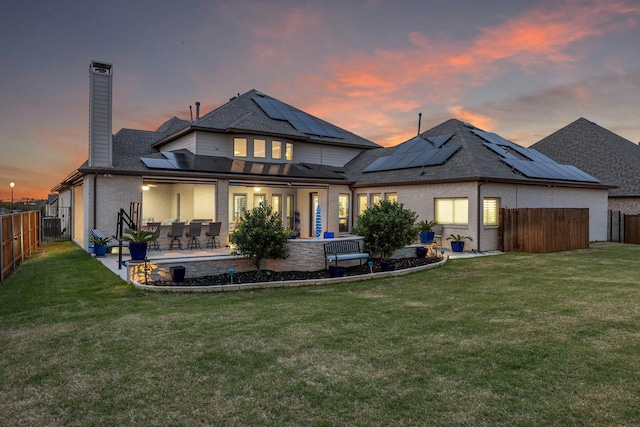 2604 Coyote Xing, Rockwall, TX 75087 - rear view of house featuring a chimney, solar panels, and a patio area