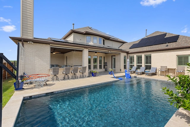 2604 Coyote Xing, Rockwall, TX 75087 - rear view of house with ceiling fan, a chimney, a patio, solar panels, and an outdoor pool