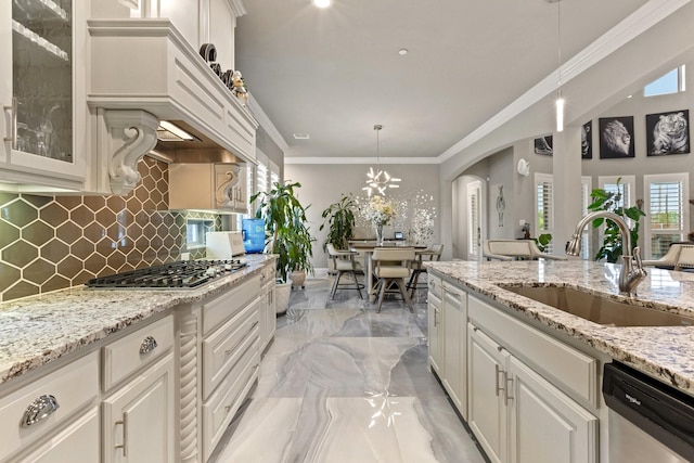 2604 Coyote Xing, Rockwall, TX 75087 - kitchen featuring stainless steel appliances, a sink, light marble finish flooring, tasteful backsplash, and hanging light fixtures