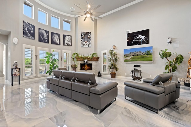 2604 Coyote Xing, Rockwall, TX 75087 - living area featuring crown molding, light marble finish flooring, ceiling fan, baseboards, and a warm lit fireplace