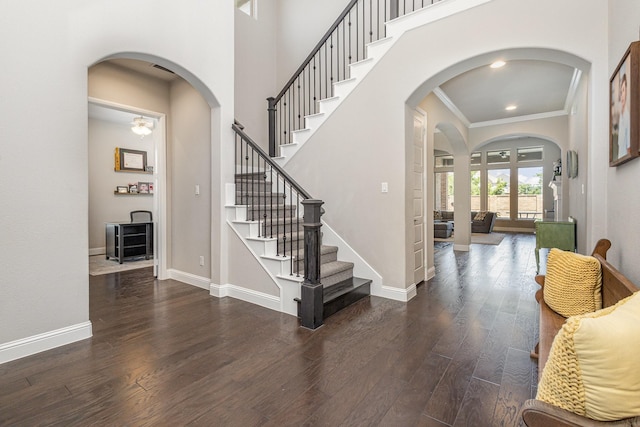 1607 Lilac Ln, Celina, TX 75009 - foyer entrance featuring arched walkways, ornamental molding, wood finished floors, stairs, and baseboards