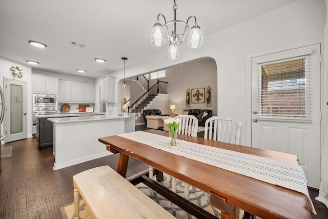 7608 White Fawn Rd, Arlington, TX 76002 - dining space featuring stairway, dark wood finished floors, arched walkways, a chandelier, and recessed lighting