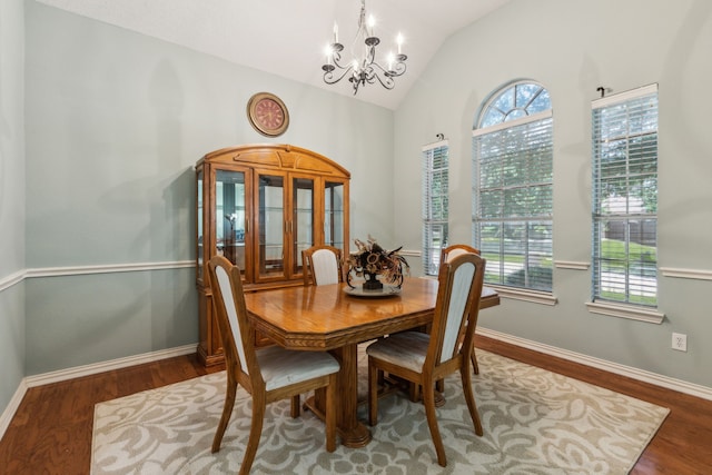 dining space with a chandelier, wood finished floors, healthy amount of natural light, baseboards, and high vaulted ceiling