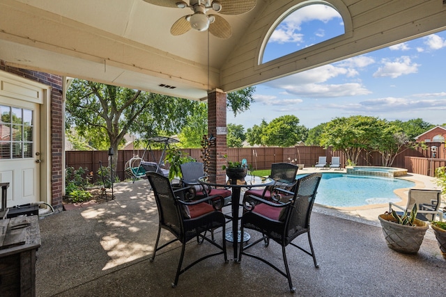 view of patio featuring a ceiling fan, a fenced backyard, a pool with connected hot tub, and outdoor dining space