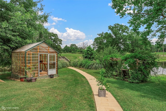561 Linton Rd, Benton, LA 71006 - view of grassy yard with a greenhouse, an outbuilding, and view of wooded area