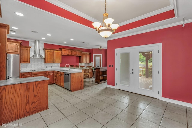 561 Linton Rd, Benton, LA 71006 - kitchen featuring stainless steel appliances, wall chimney range hood, a peninsula, french doors, and tasteful backsplash
