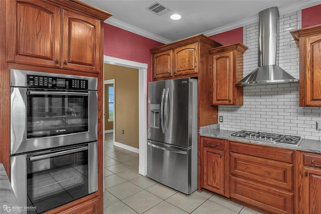 561 Linton Rd, Benton, LA 71006 - kitchen with appliances with stainless steel finishes, wall chimney exhaust hood, light tile patterned flooring, tasteful backsplash, and crown molding