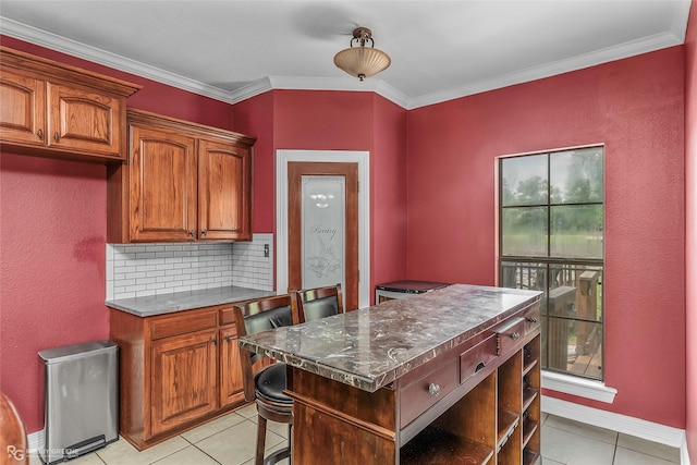 561 Linton Rd, Benton, LA 71006 - kitchen with light tile patterned floors, a desk, tasteful backsplash, brown cabinetry, and crown molding