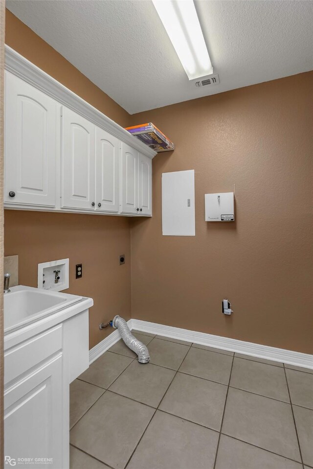 561 Linton Rd, Benton, LA 71006 - laundry area with electric dryer hookup, baseboards, cabinet space, light tile patterned floors, and hookup for a washing machine
