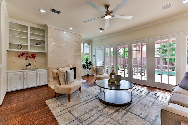 7627 Sweetgum Dr, Irving, TX 75063 - living area featuring ceiling fan, crown molding, a tile fireplace, recessed lighting, and dark wood-style flooring