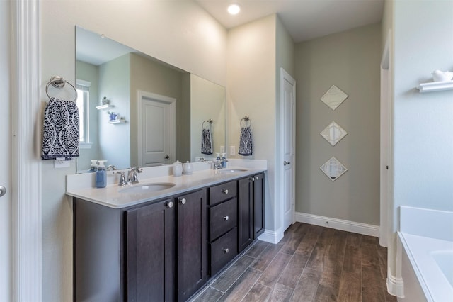 11312 Culberson Dr, Aubrey, TX 76227 - full bathroom with wood finished floors, baseboards, a tub to relax in, and double vanity