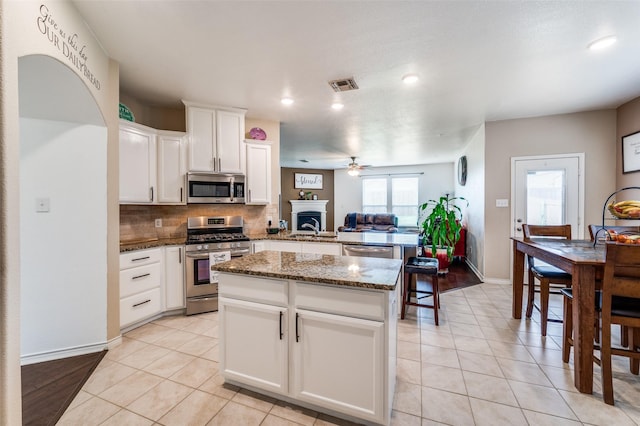 820 Lake Sierra Way, Little Elm, TX 75068 - kitchen featuring appliances with stainless steel finishes, a sink, ceiling fan, light tile patterned flooring, and decorative backsplash