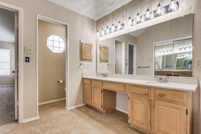 7816 Hardwick Ct, Plano, TX 75025 - bathroom with double vanity, healthy amount of natural light, tile patterned flooring, and baseboards