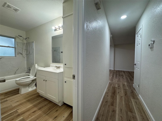 140 Shirley Dr, Lacy Lakeview, TX 76705 - full bath with a textured wall, wood finished floors,  shower combination, vanity, and toilet