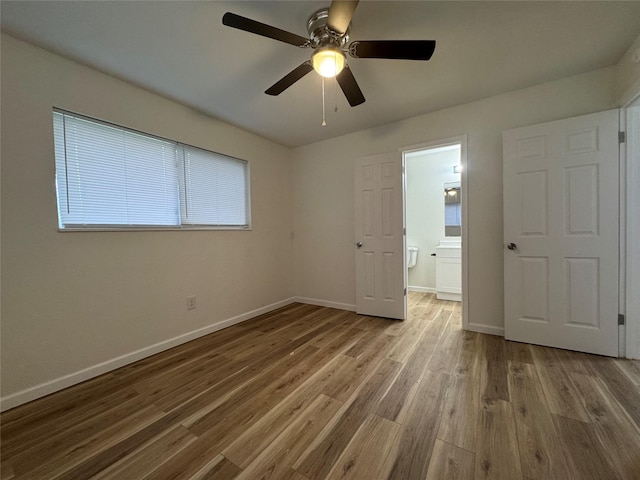 140 Shirley Dr, Lacy Lakeview, TX 76705 - unfurnished bedroom featuring wood finished floors, baseboards, ensuite bathroom, and a ceiling fan