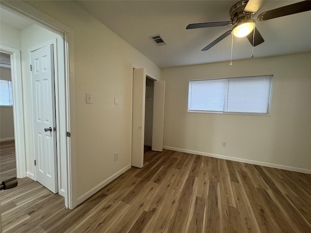 140 Shirley Dr, Lacy Lakeview, TX 76705 - unfurnished bedroom featuring wood finished floors, baseboards, multiple windows, and a ceiling fan