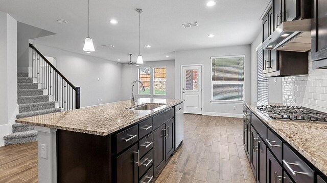 8721 Leafy Ln, Justin, TX 76247 - kitchen featuring a sink, appliances with stainless steel finishes, wood finished floors, recessed lighting, and decorative backsplash