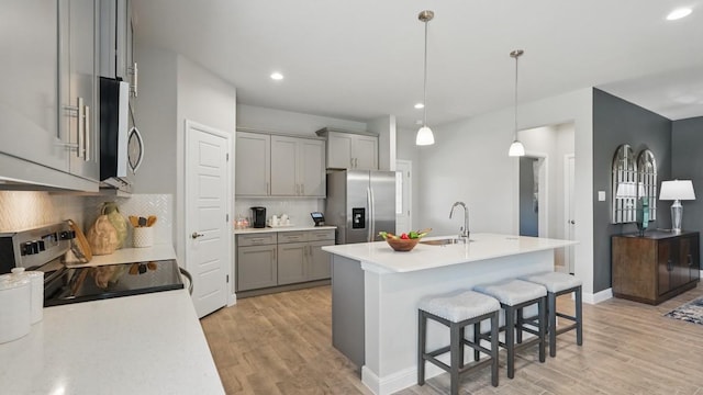 1303 Finley Dr, Mansfield, TX 76063 - kitchen with stainless steel appliances, gray cabinets, a sink, light wood finished floors, and recessed lighting