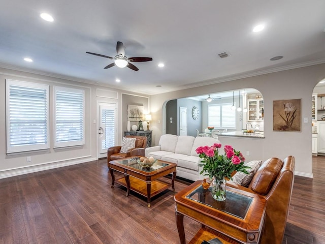 13026 Brook Ridge Dr, Frisco, TX 75035 - living room with arched walkways, a ceiling fan, ornamental molding, dark wood-style flooring, and recessed lighting
