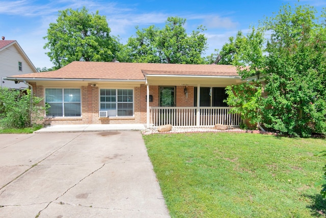 ranch-style home featuring covered porch, brick siding, a front lawn, and concrete driveway