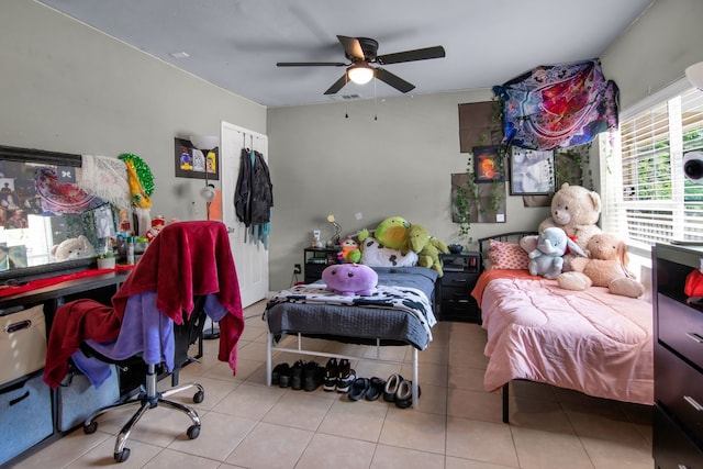 tiled bedroom with a ceiling fan