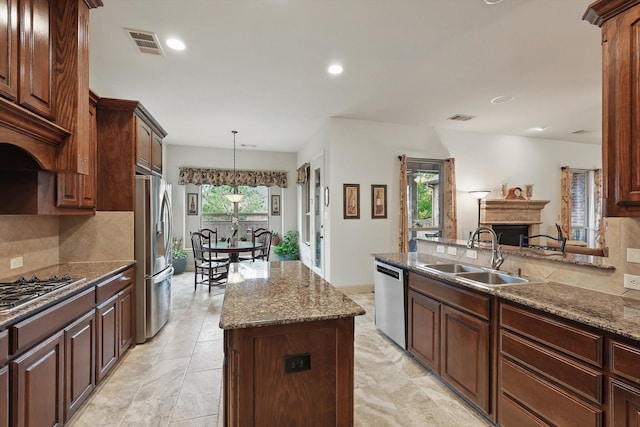 2801 Spring Oaks Dr, Highland Village, TX 75077 - kitchen with a sink, appliances with stainless steel finishes, decorative backsplash, a center island, and recessed lighting