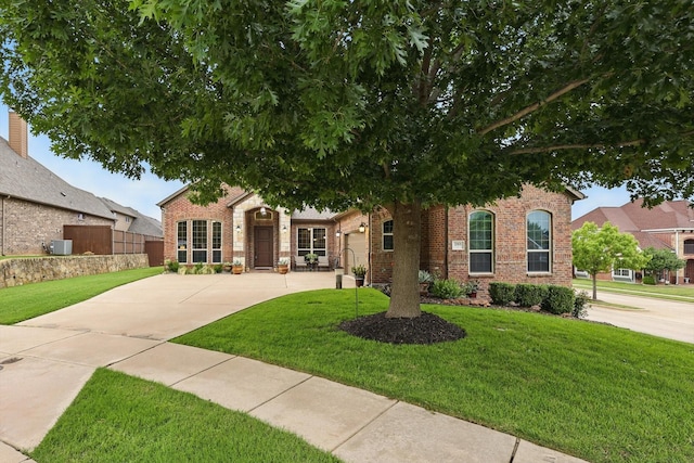 2801 Spring Oaks Dr, Highland Village, TX 75077 - obstructed view of property featuring brick siding, driveway, and a front lawn