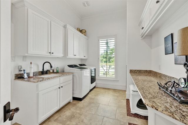 laundry room featuring washing machine and dryer, cabinet space, ornamental molding, and light tile patterned floors