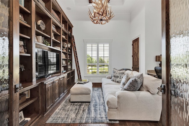 sitting room with a chandelier, dark wood-type flooring, and a high ceiling