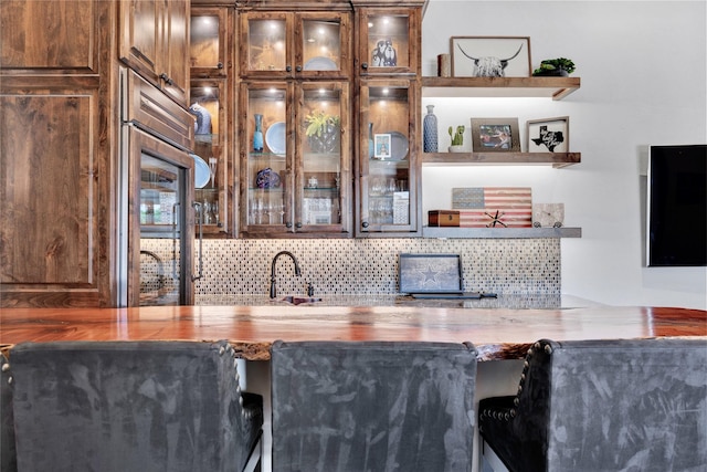 indoor wet bar featuring tasteful backsplash