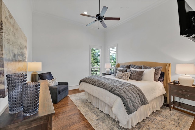 bedroom featuring ornamental molding, wood finished floors, a ceiling fan, and baseboards