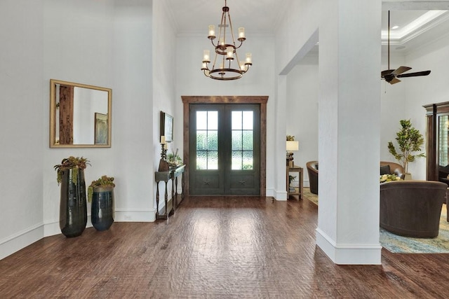 foyer with a towering ceiling, wood finished floors, french doors, a chandelier, and baseboards
