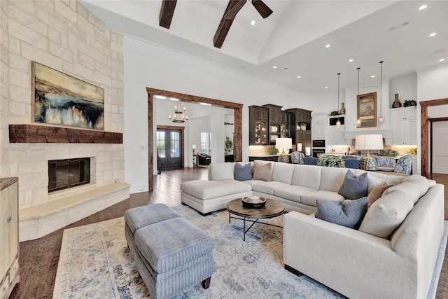 living area featuring high vaulted ceiling, a chandelier, recessed lighting, ceiling fan, and a stone fireplace