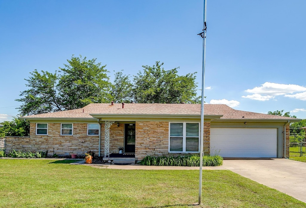 6115 Overlake Dr, Fort Worth, TX 76135 - ranch-style house with a front yard, concrete driveway, an attached garage, and stone siding
