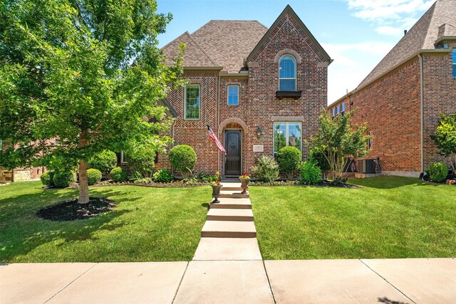 12092 Burnt Prairie Ln, Frisco, TX 75035 - view of front of property with a front lawn, brick siding, central air condition unit, and roof with shingles