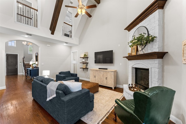 12092 Burnt Prairie Ln, Frisco, TX 75035 - living room featuring high vaulted ceiling, arched walkways, ceiling fan, a fireplace, and dark wood-style flooring